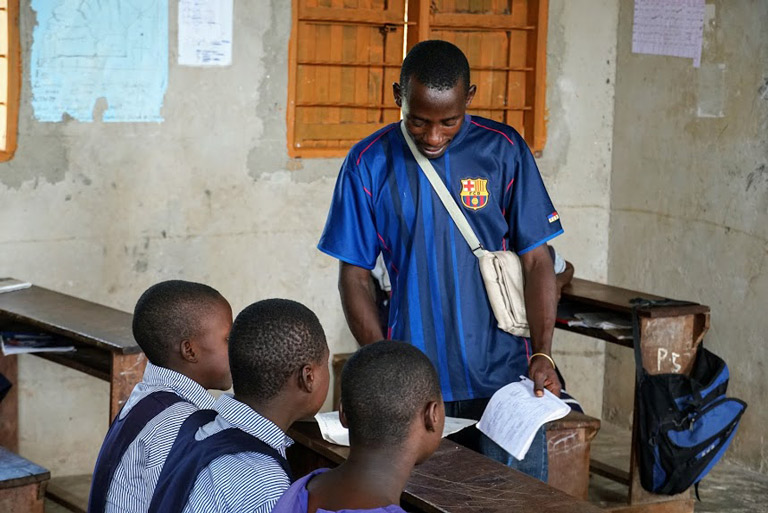 CEV Bashir helps students inside a classroom