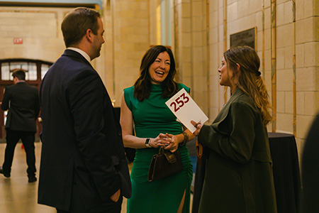 A group of guests laugh while conversing in the Grand Hall