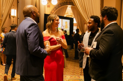 A group of guests chats and laughs during cocktail hour