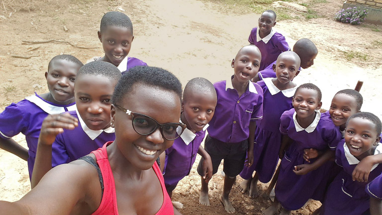 Fellow Namata takes a selfie with a group of students